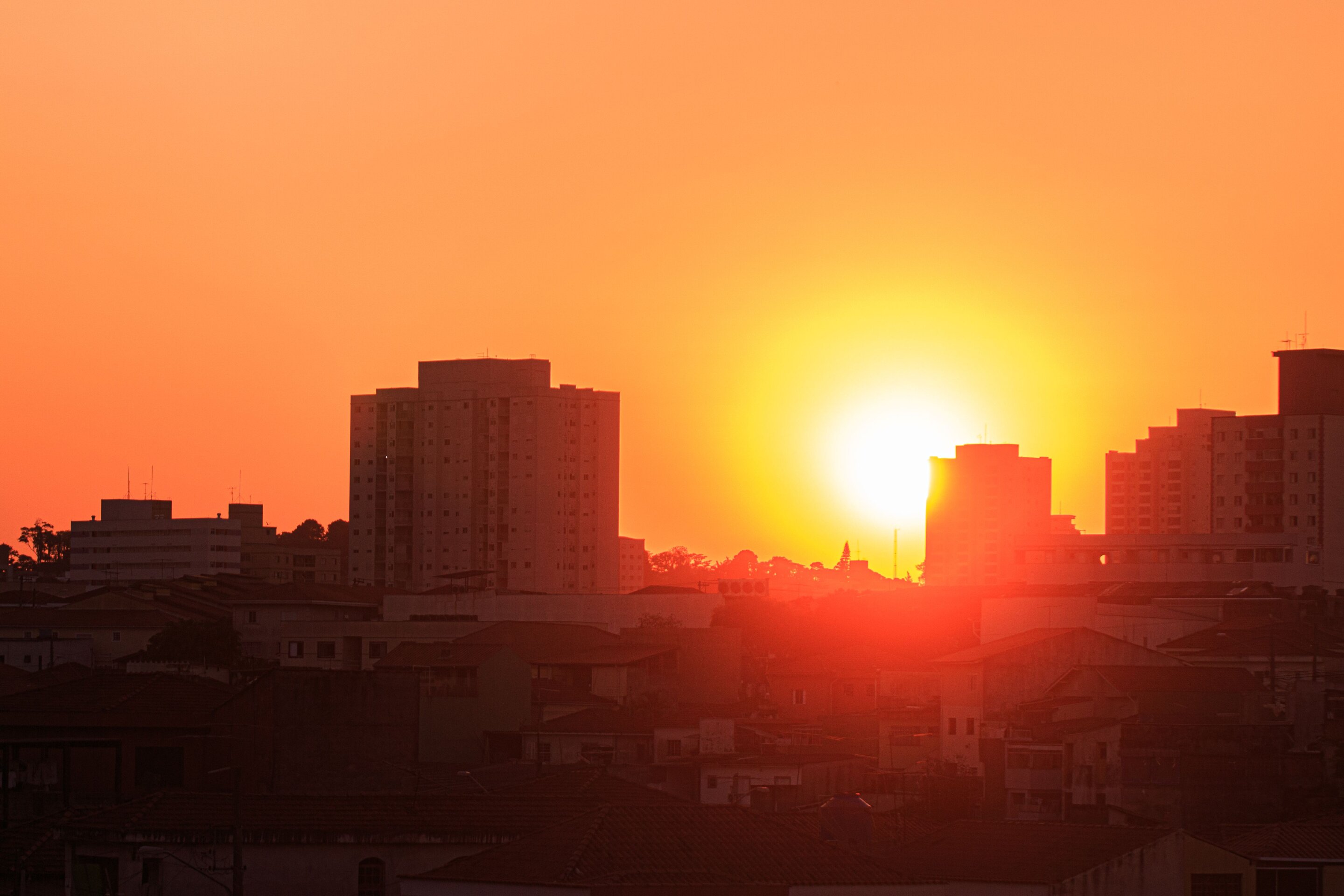 Sol bajo sobre edificios de una zona urbana al atardecer