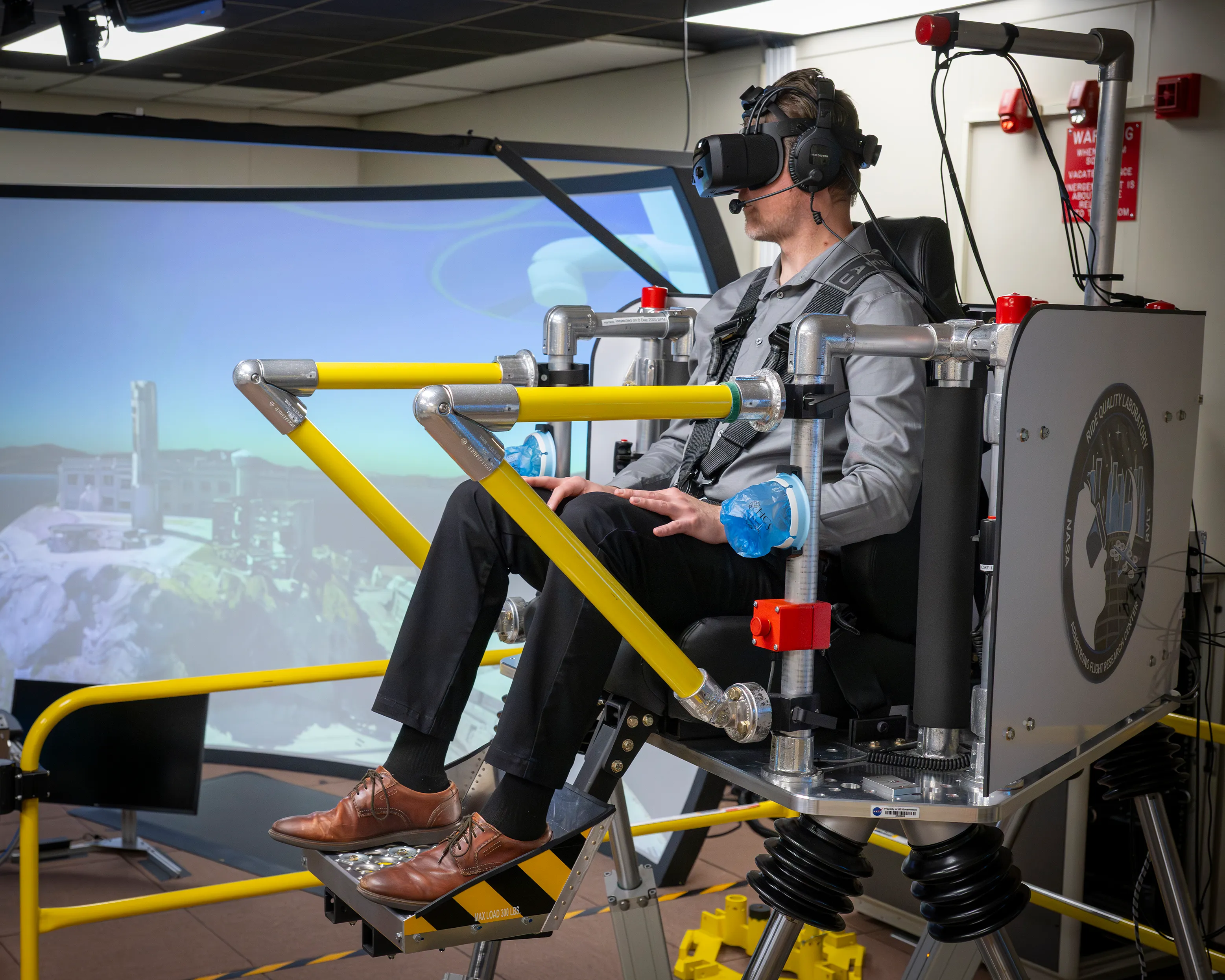 Pasajero sentado en un simulador de movimiento con visor de realidad virtual durante una prueba de confort para futuros taxis aéreos.