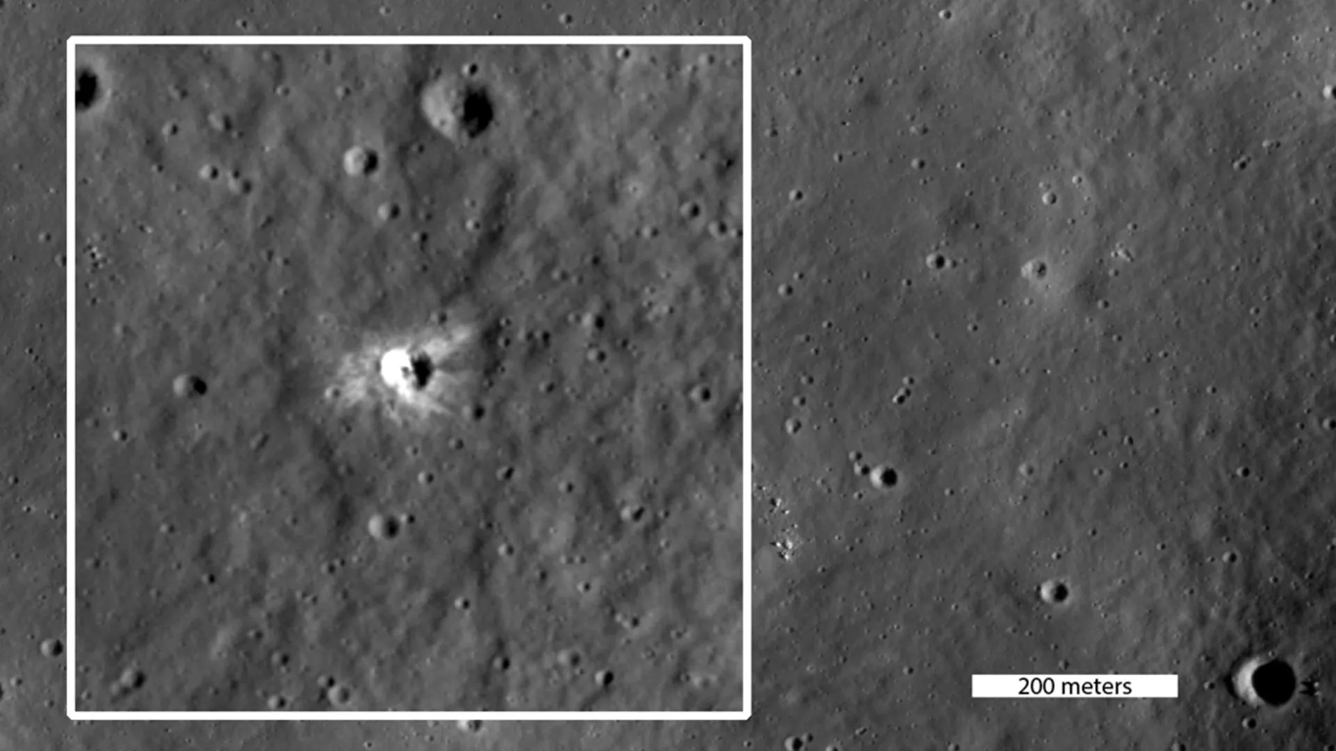 Un cráter lunar reciente rodeado por rayos claros de material expulsado sobre una zona oscura de la superficie.