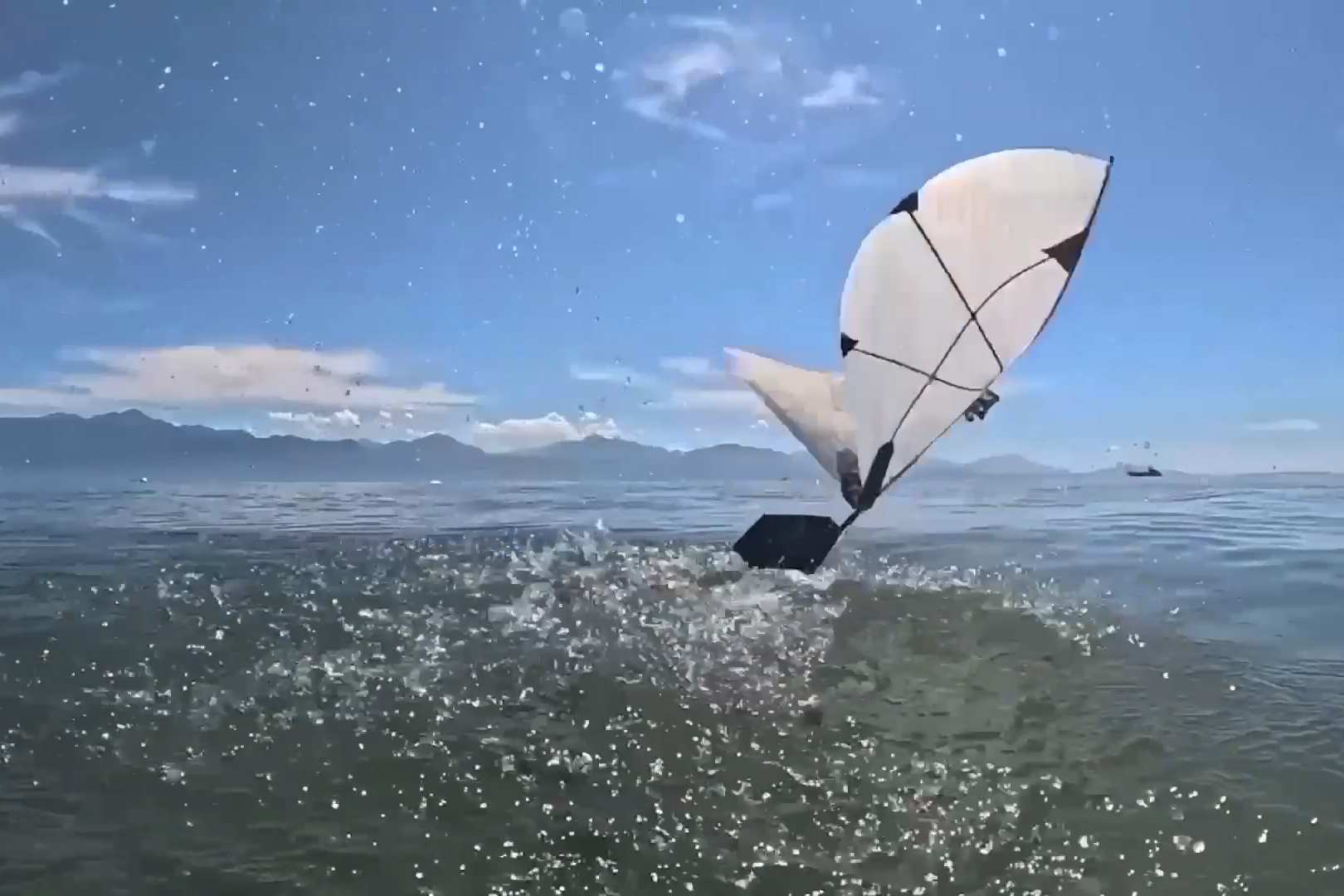 Robot pequeño con alas batientes emergiendo del agua para continuar su desplazamiento en el aire, en una imagen difundida por MIT
